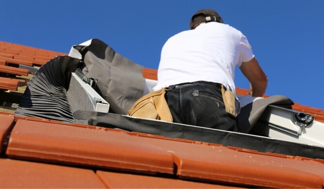 man installing a velux skylight on a roof